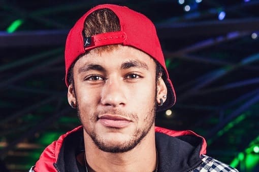 Foto de Neymar Jr usando um boné vermelho para trás.