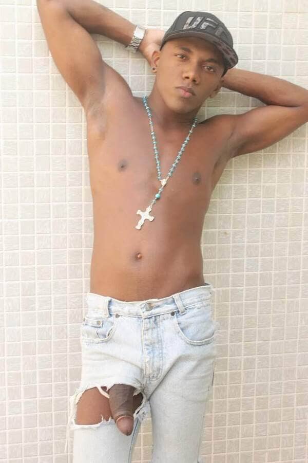 Renan Maranhão de bonê, rosário no pescoço, sem camisa, usando calça jeans.